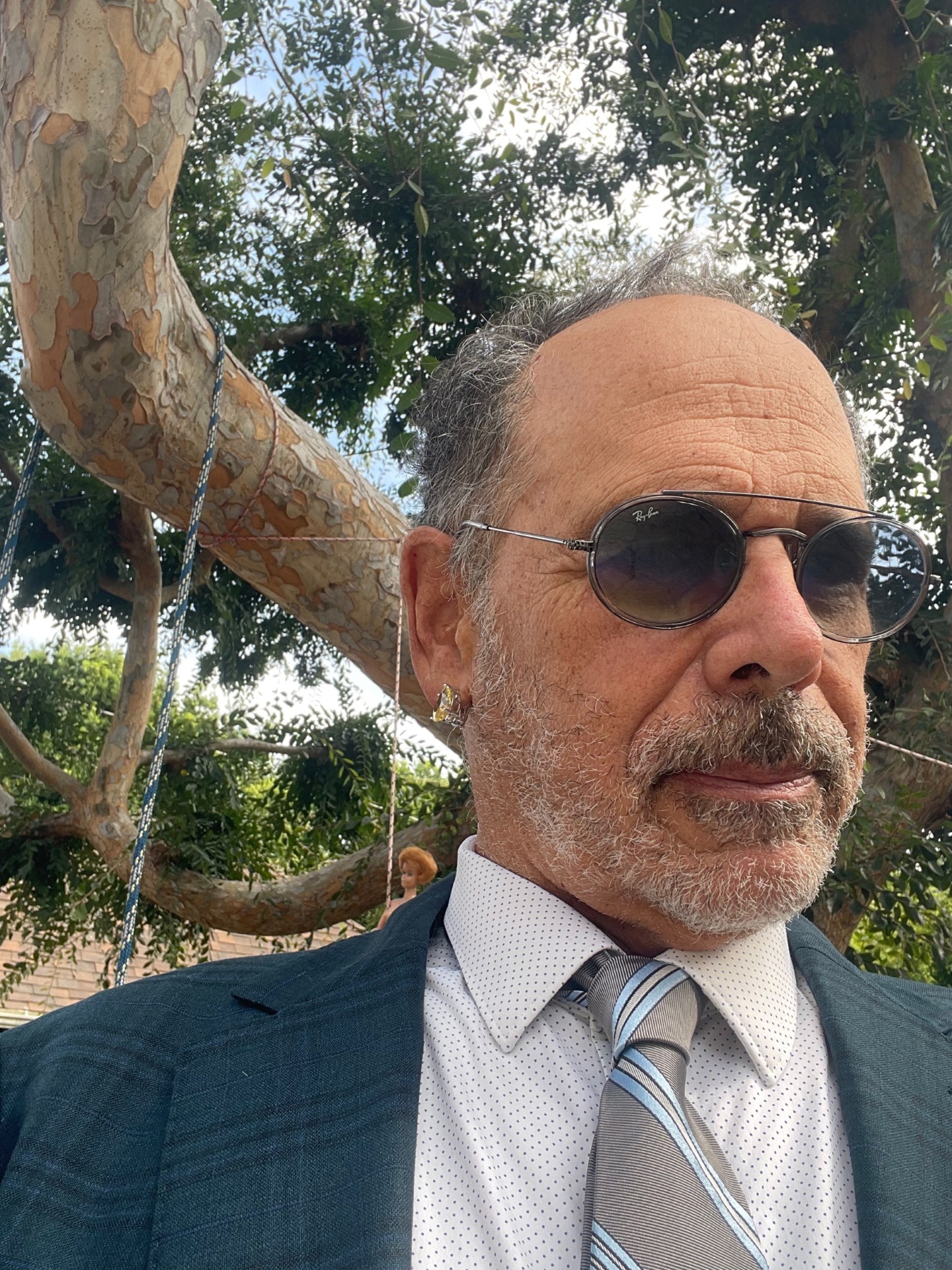 Henry Weil in suit and tie beneath a sycamore
